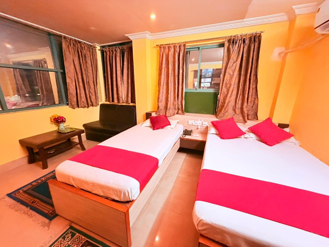 AC guest room with a double bed, single bed, sofa and curtained windows