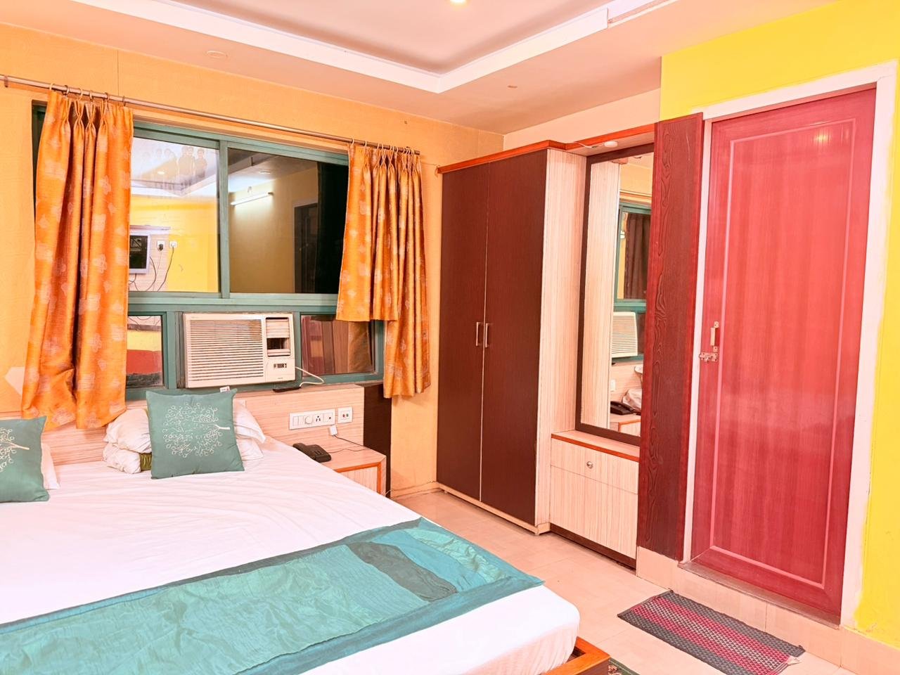 Guest room with double bed, wardrobe with mirror and entrance door